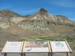 View of John Day Fossil Beds from Highway Overlook, 1 Mi North of US 26 on Oregon Route 19, near Dayville OR This (second)overlook gives the ZMM Traveler an a (second)excellent panorama of this tortured dry desolate land. Much of the mountain in this view is volcanic ash. A horizontal dark band seen from this Overlook reveals an ancient volcanic lava flow. (Photo = 112-1292_IMG.JPG)