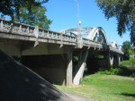 An Interesting Pair of Arched Bridges by City Park.  I needed a cool place to rest, eat lunch and study maps. So when I saw a wider place in the busy highway, I pulled over and walked down the bank to the river edge. Cool! Nice!!  Grants Pass, OR.  114-1497_IMG.JPG