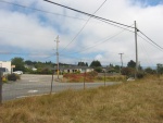 The Old Pavement of Rt 101 Has Headed Inland. It Is Much Warmer and We have Escaped the Cold Fog.  Ahead a large flowering bush colors the landscape.  Old Coast Highway Turns to enter McKinleyville, CA.  (Photo = 116-1623.JPG)
