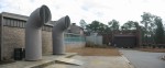 Panorama View of 1) "Air Intake Horns" For Science Building Ventilation System, 2) Biology Department Greenhouse Windows, 3) Distant HVAC Cooling Tower, and 4) Small Building To House Aquaria for Octopus Research.  These pipes lead down to the HVAC Equipment Room. Photos of this area will be found in a separate album of this Photo Gallery.  Science Building,  USCA Campus, Aiken, SC.  ************************************  (Photo = 5168+3scz ...... WayPt = `000 |w|' 420 ft)