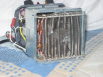 This Electric Heater Put Too Many Amps Through a Tiny Crimp Connector Holding The Two Hot-Wire Heater Elements. It Soon Burned and Vaporized the Connector! I  Repaired  It By Crimping the Hot-Wires Tight With the Copper Spirals Around the Longer Vertical Copper Wire Seen At Left. Photo = 4791. 