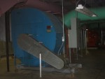Close-Up View of Ventilation Centrifugal Blower Fan That Forces Re-circulated Building Air Into the System Filter and Conditioning Compartments Mentioned In Previous Photo.  As discussed in the previous photo, the Two Light Green Pipes Bring Partially Used Air From Various Collector Funnels in the Building to the Mostly Obscured Grey Box at Right Rear. This box filters and conditions the air to be re-circulated back to the building (pink ducts) by a large centrifugal blower fan which is the circular blue object in the background.  HVAC Equipment Room, Basement of Science Building, USCA Campus, Aiken, SC.  ************************************  (Photo = 5149 ...... WayPt = `000 |w|' 420 ft)