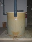 Collection and Treatment Vessel For Chemistry/Biology/Geology/Physics Lab Waste Water.  This container collects and holds all the sink drains waste water from all the labs. Periodically this waste water it is tested and neutralized prior to release into the public sewer. This tank is made from polyethylene plastic, hence the white color. Polyethylene plastic is quite resistant to corrosion and relatively inexpensive and is easy to fabricate into tanks like this. Thus polyethylene plastic is the most cost effective material for this application.  HVAC Equipment Room, Basement of Science Building, USCA Campus, Aiken, SC.  ************************************  (Photo = 5151 ...... WayPt = `000 |w|' 420 ft)