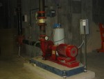This Pump Moves Water To and From the Air Conditioner's Cooling Tower At the Exterior East End of the Science Building.  The electrical drive motor is the cylinder in the foreground and the circular housing of this centrifugal pump is behind. Note pressure gauge. Which of the two pipes attached to the pump is the inlet to this pump and which is the outlet. Hint which way does the motor rotate? Think!!  HVAC Equipment Room, Basement of Science Building, USCA Campus, Aiken, SC.  ************************************  (Photo = 5152 ...... WayPt = `000 |w|' 420 ft)